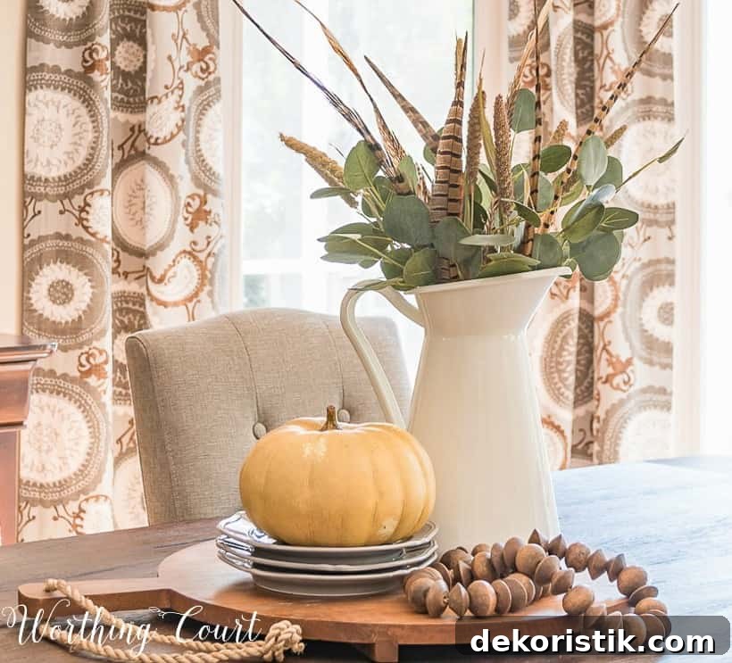 Fall centerpiece with wood beads and faux greenery in white pitcher.