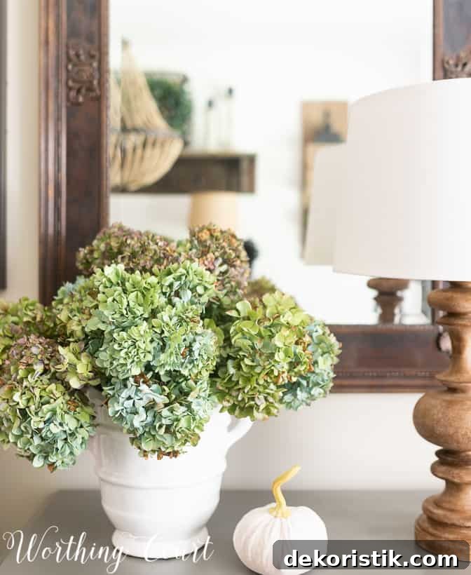 dried blue and green hydrangea arrangement in a white vase