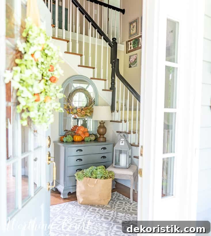 Minimal Fall Foyer Decor Ideas for a Welcoming Entry 2 Fall foyer decorations with pumpkins on a gray chest.