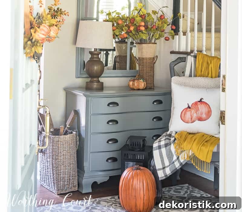 Minimal Fall Foyer Decor Ideas for a Welcoming Entry 11 Foyer decorated for fall with a pumpkin on the floor, and fall leaf decor.