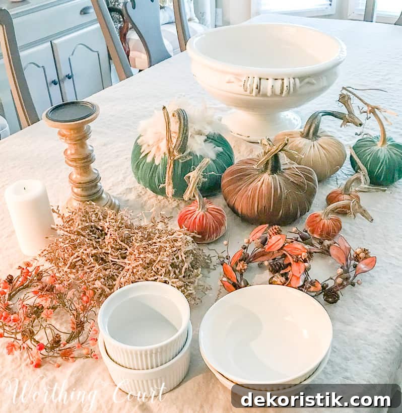 The velvet pumpkins, bowls, candlestick, with a candle and the white urn on the table.