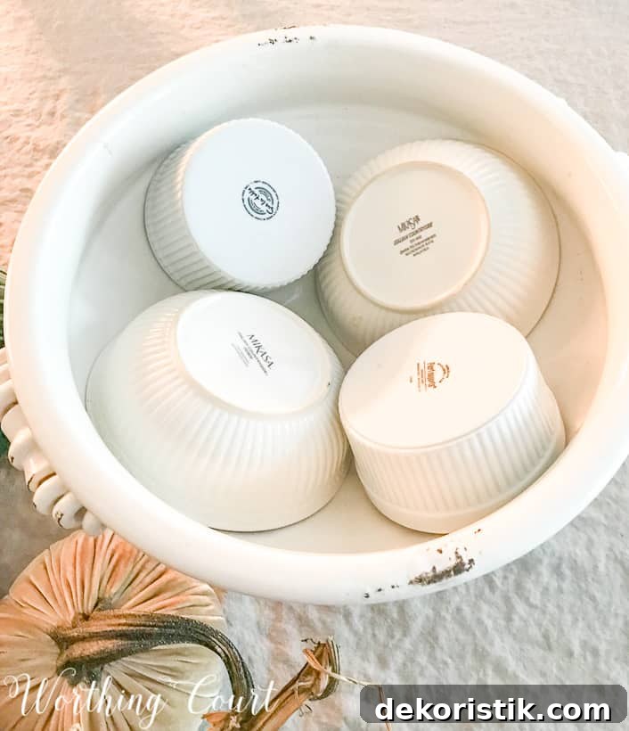 Placing the bowls upside down in the white urn.
