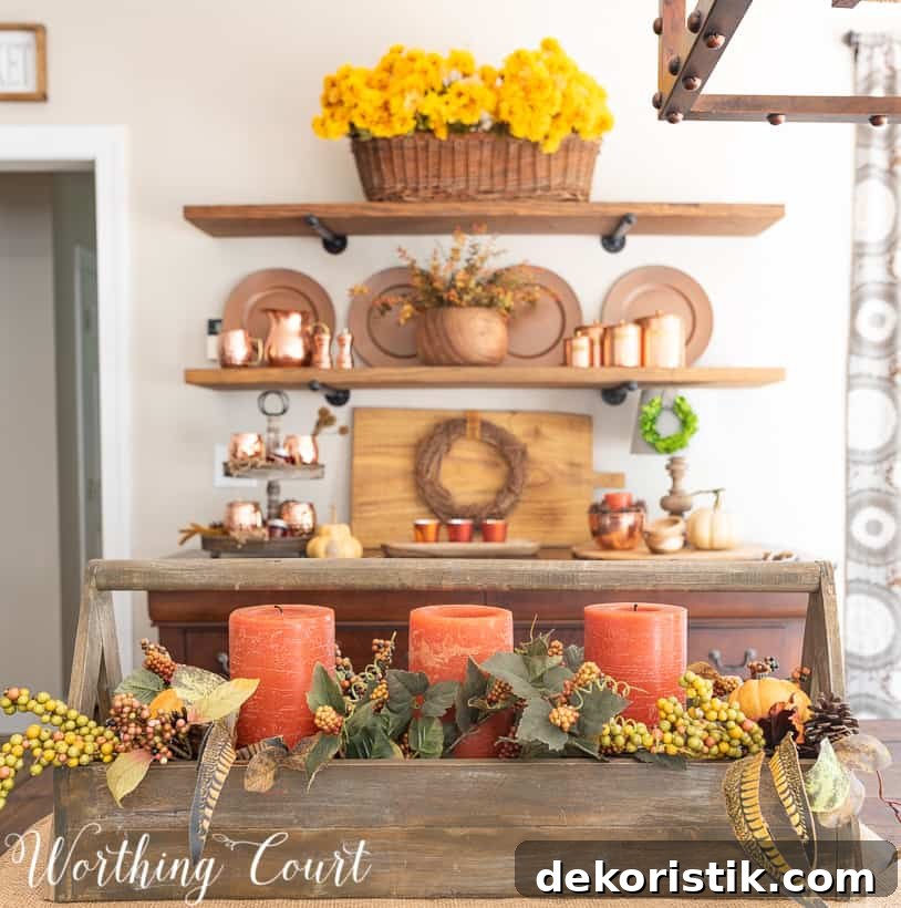 Fall centerpiece with traditional fall colors and orange candles.