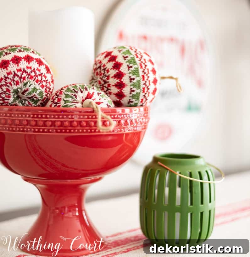 A red pedestal bowl filled with fabric ornaments.