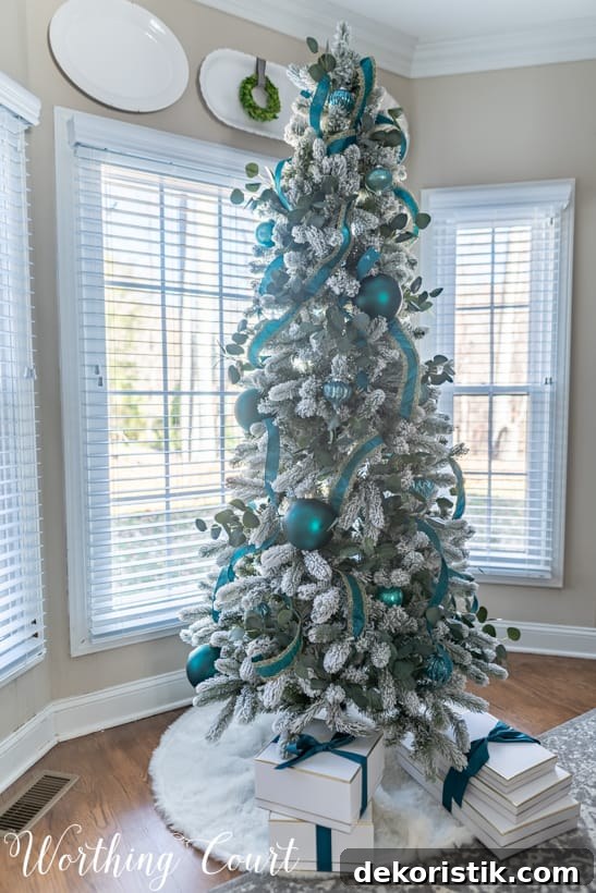 Flocked Christmas tree near the bay windows.