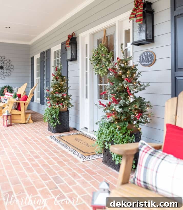 Christmas front porch with Adirondack chairs that have plaid and red pillows on them.
