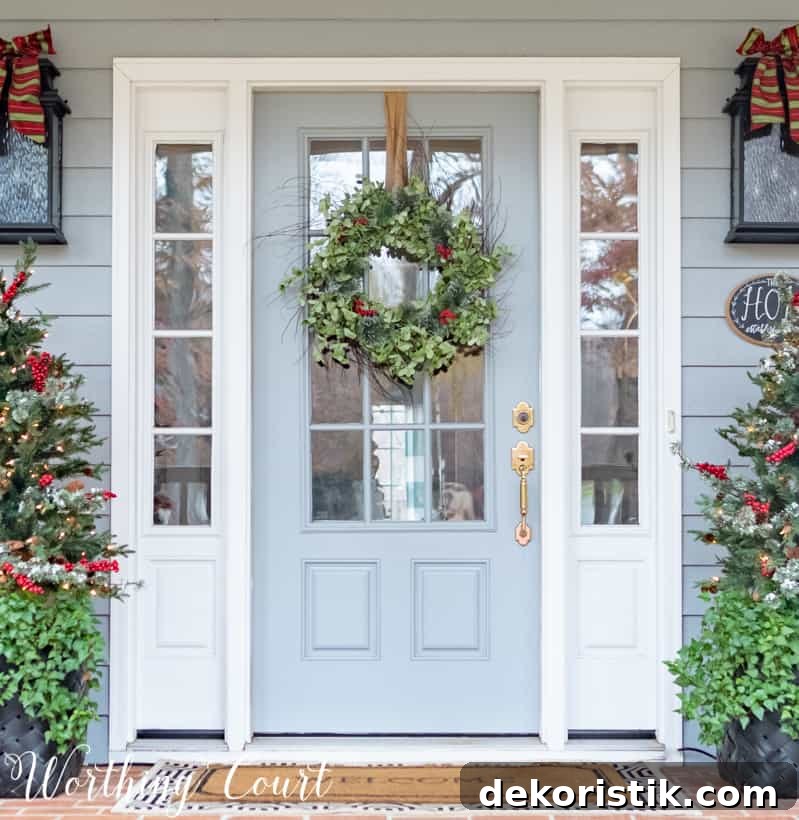 A light blue door with a green wreath and berries on it.