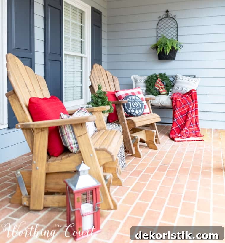 Adirondack chairs with red and plaid cushions and throw blankets are on the chairs.