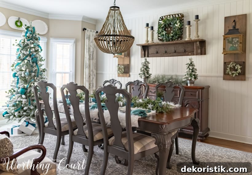 Teal Christmas dining room decorations with a large decorated tree at the foot of the dining room table.