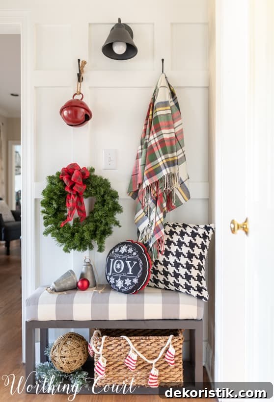 A throw blanket is hanging beside a wreath on the wall.