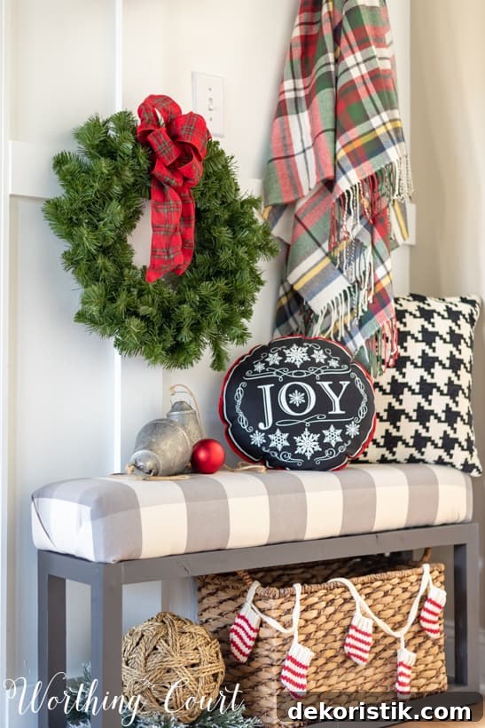 Christmas decorations on a bench with a JOY pillow.