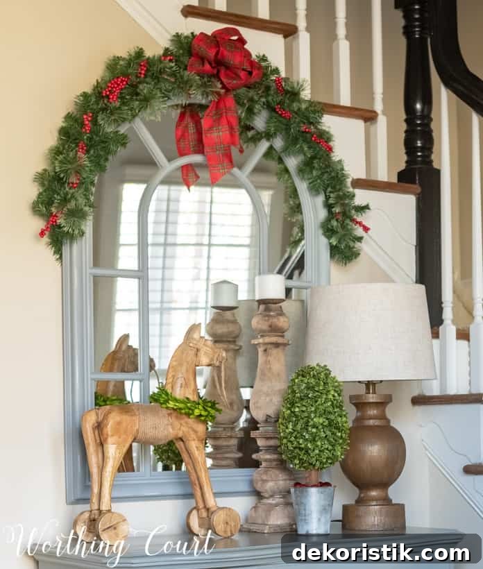 The mirror in the foyer decorated with garland and ribbon.