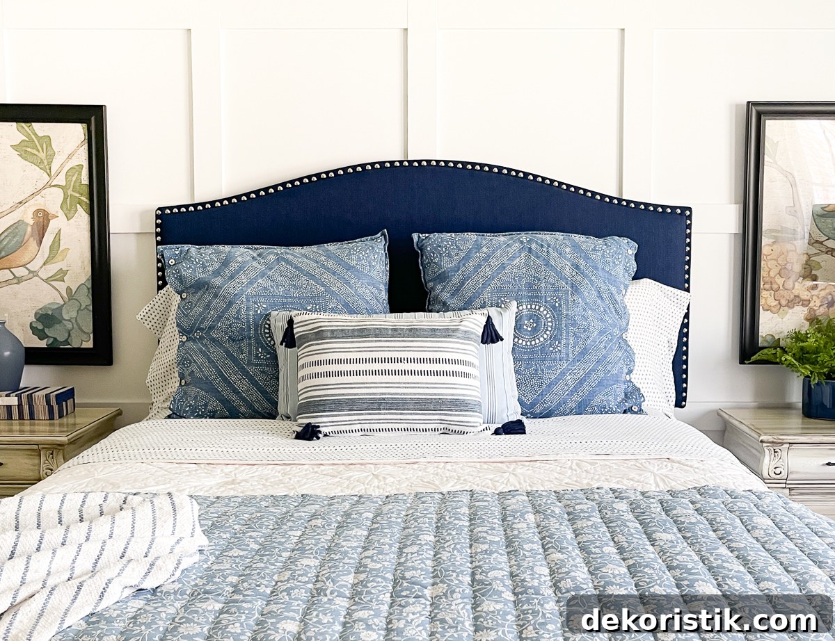 cottage style budget bedroom makeover with a navy blue upholstered headboard, board and batten feature wall, diy painted furniture and cottage style accessories