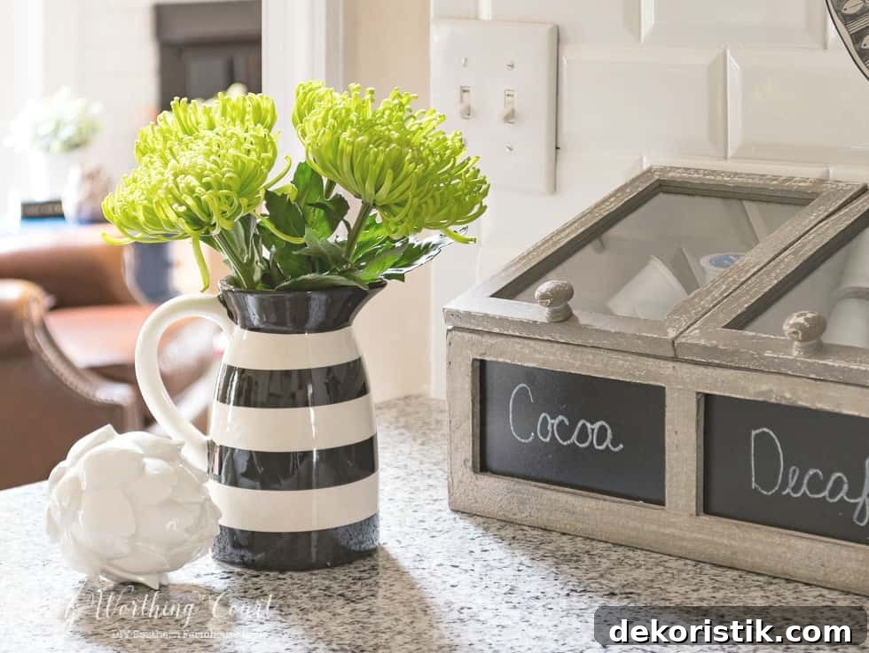 6 Spring Home Decor Items to Refresh Your Space 9 Black and white pitcher filled with bright green flowers.