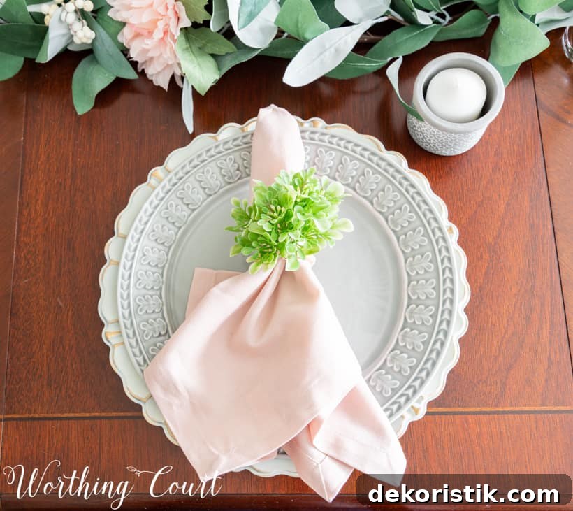 Table setting with gray dinner plate and pink napkin.