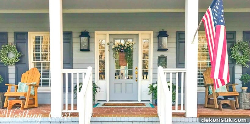 front porch with gray siding, white columns and a gray front door with sidelights