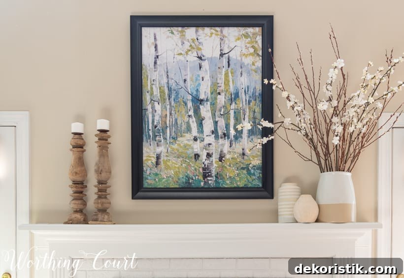 There is a vase with branches with white flowers on the mantle.