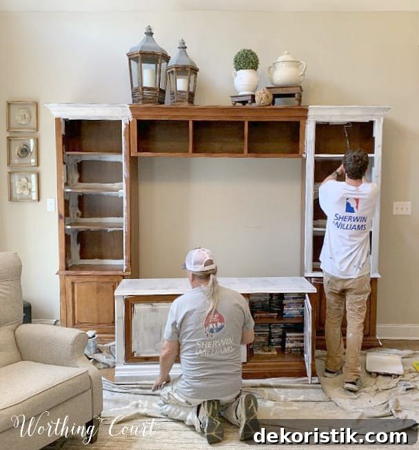 Two men painting the entertainment center.