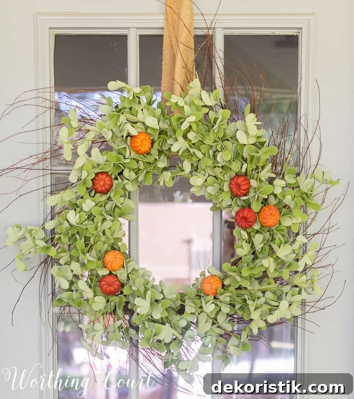 Premade eucalyptus wreath with pumpkins added for fall.