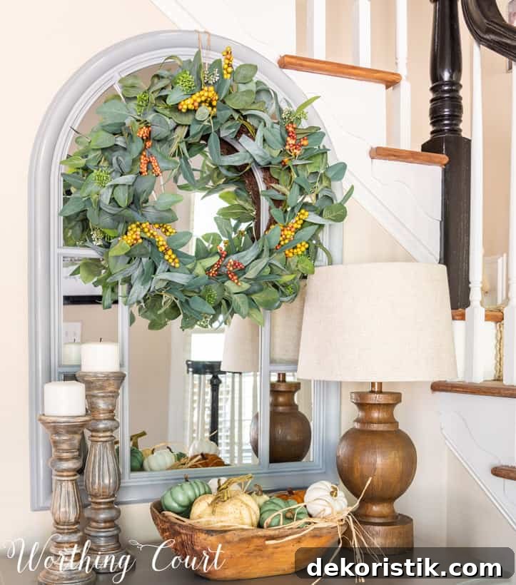 fall entry table decor with pumpkins, candlesticks and a lamp