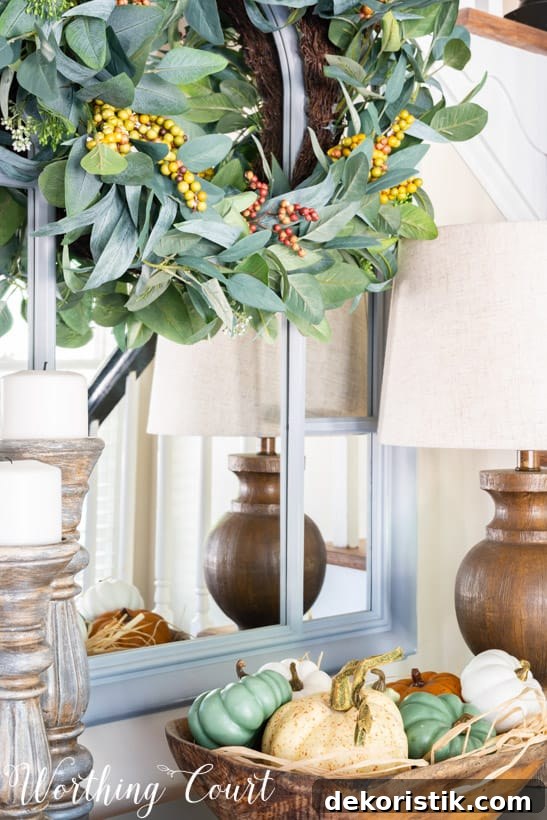 entry table decor for fall with a doughbowl filled with pumpkins