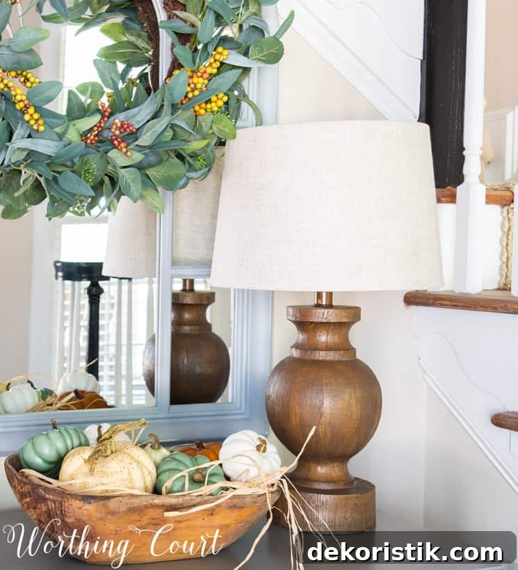 fall entry table decor with pumpkins in a wooden bowl