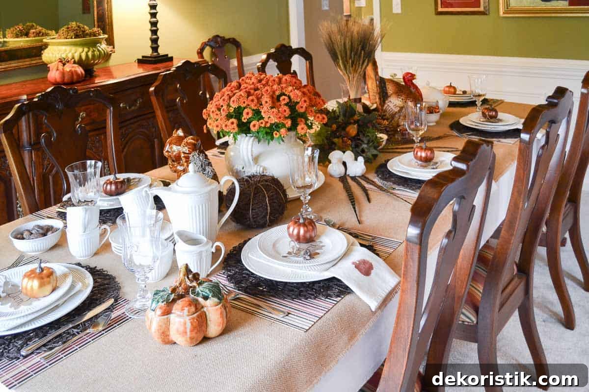 Thanksgiving tablescape with neutral linens, white dishes, and fall colored accents