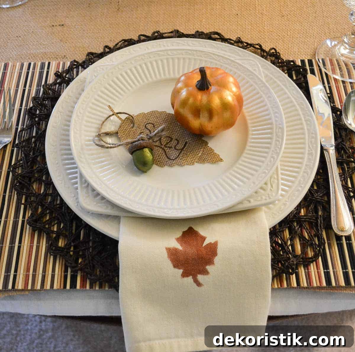 Thanksgiving tablescape with neutral linens, white dishes, and fall colored accents