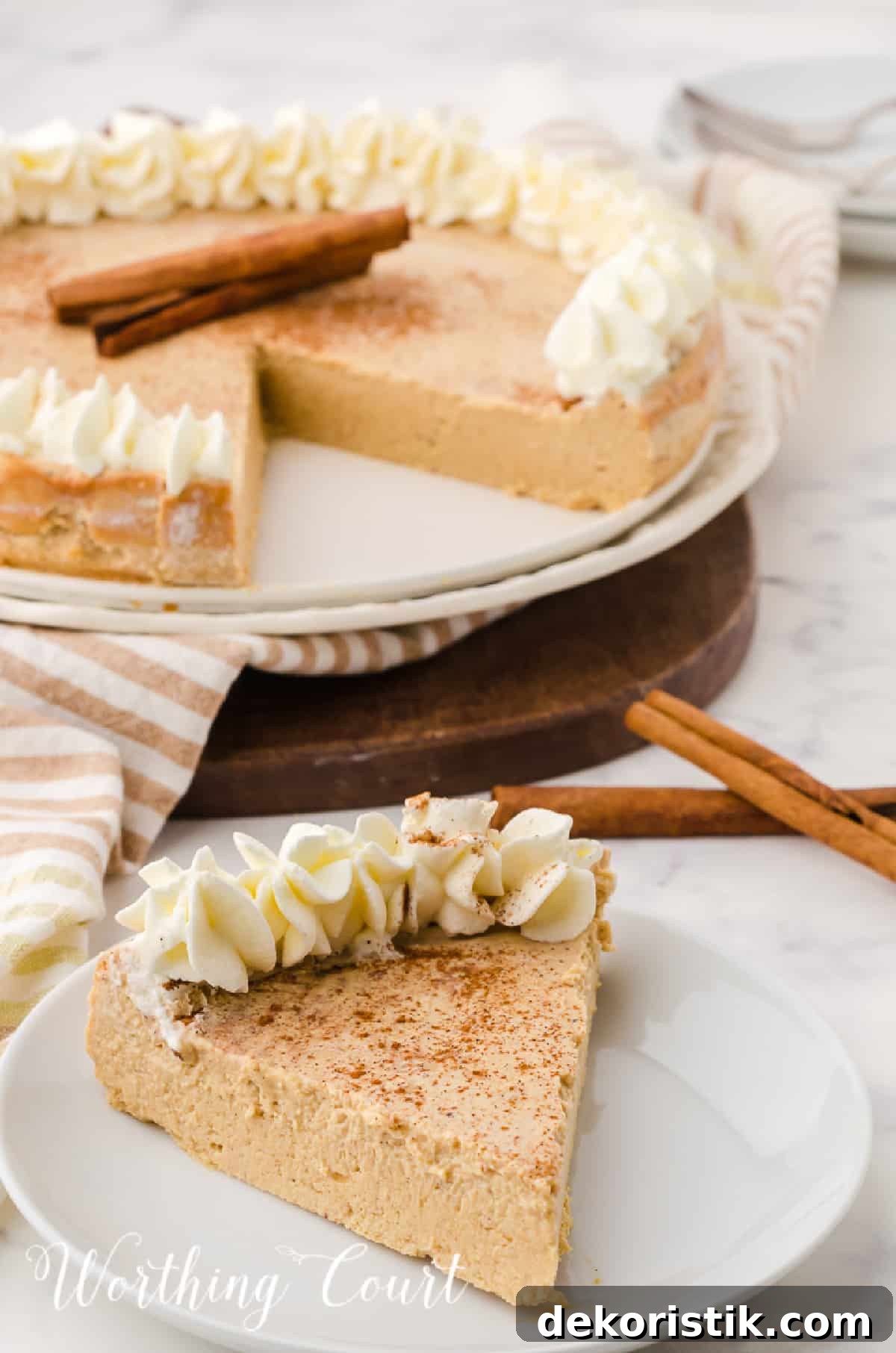 slice of ginger cheesecake on a white plate with rest of cheesecake in the background