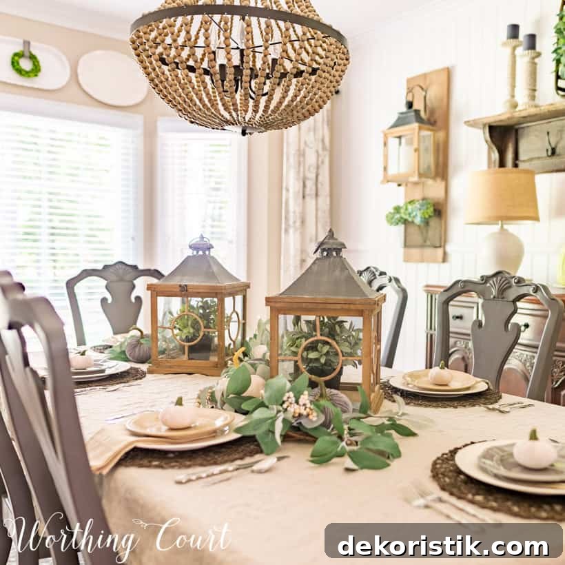 5 Tabletop Accessories to Elevate Your Thanksgiving Table 6 table setting with white tablecloth, white dishes and two lanterns