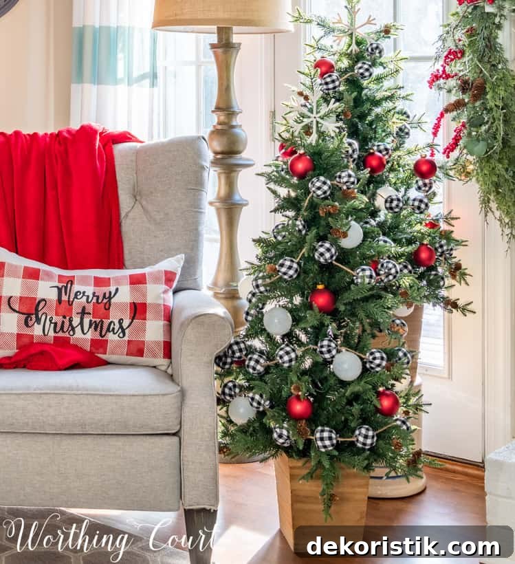 A small pillow that says Merry Christmas is on the armchair beside the tree.