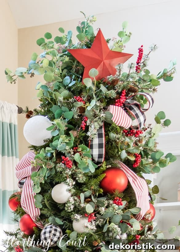 A large red star is on the top of the Christmas tree.