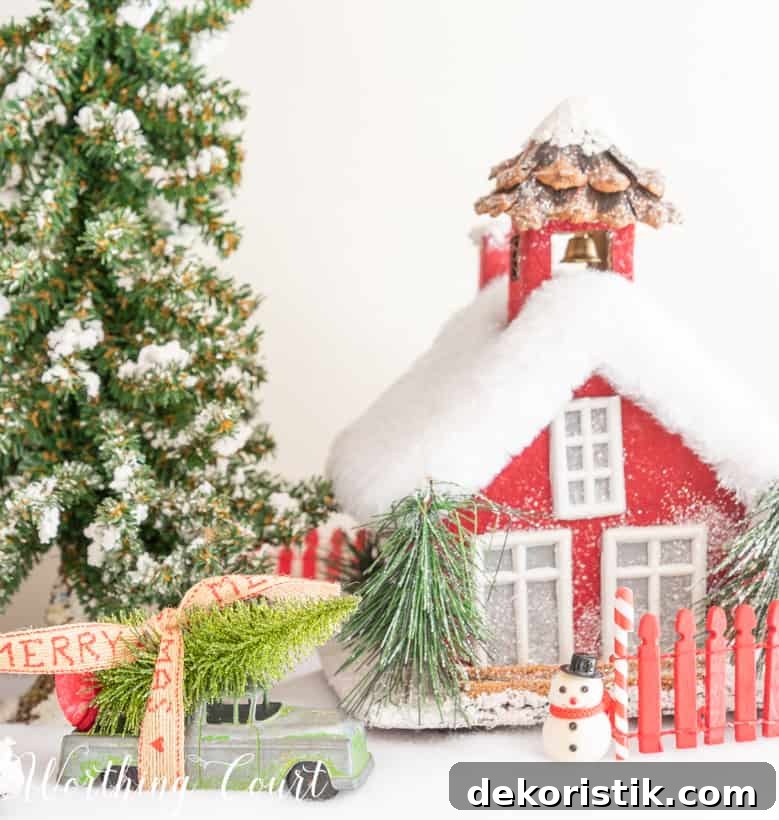 Red Christmas village house on a bed of snow.