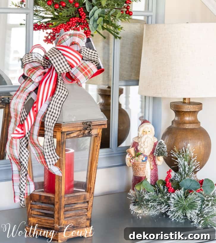 Wood and metal lantern containing a red candle with a bow made from Christmas ribbon attached to the top.