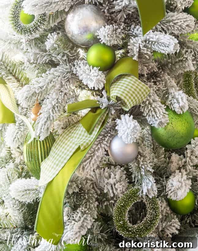 Up close picture of the green and silver ornaments on the tree.
