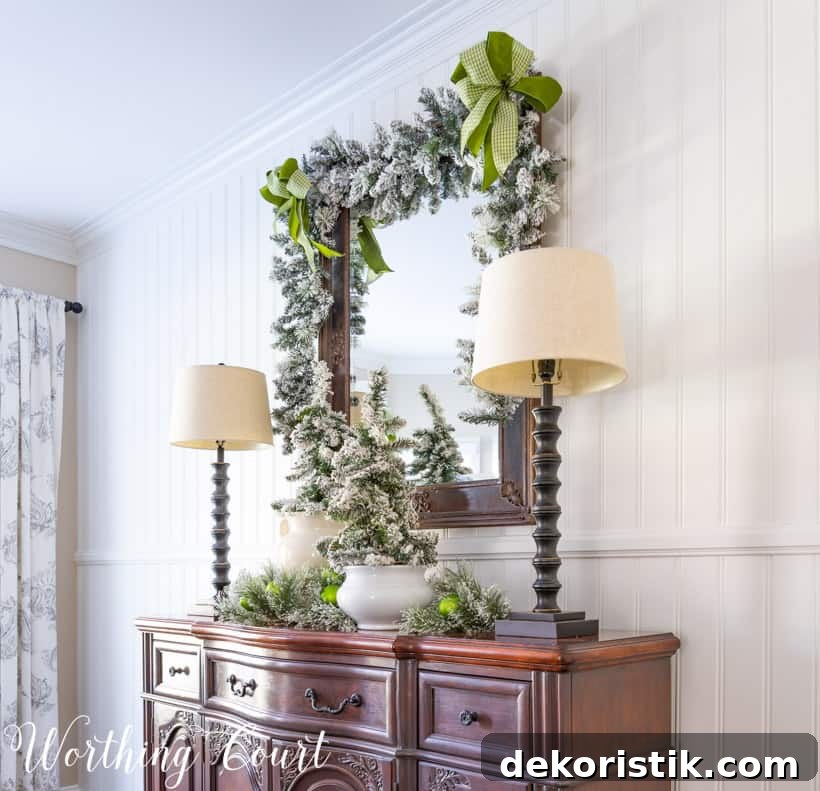 There is a garland on the mirror on the wall above the sideboard.