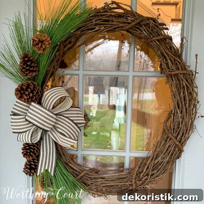 grapevine wreath with pine branches and black and white bow
