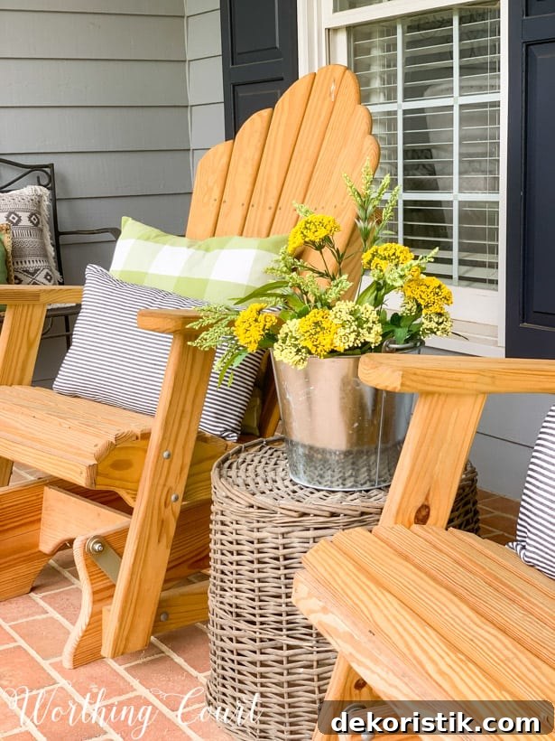 Adirondack rocker chairs with pots of yellow flowers.