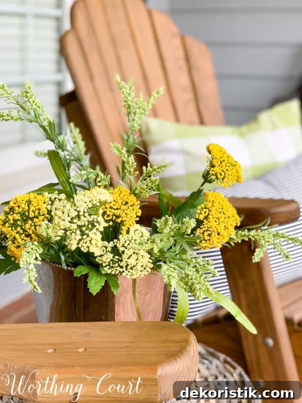 Pretty yellow flowers in a silver pot beside the chairs.