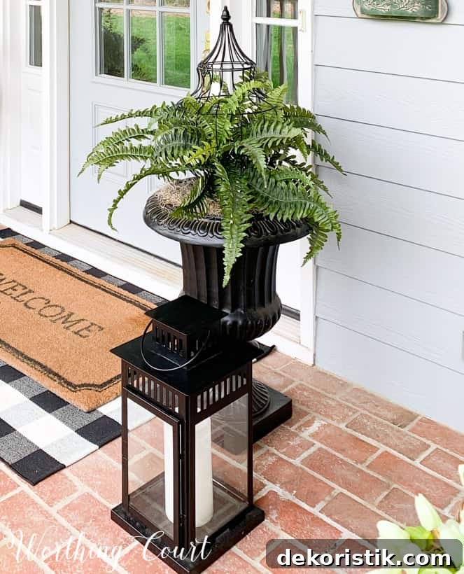 There is an urn by the front door with a fern in it.