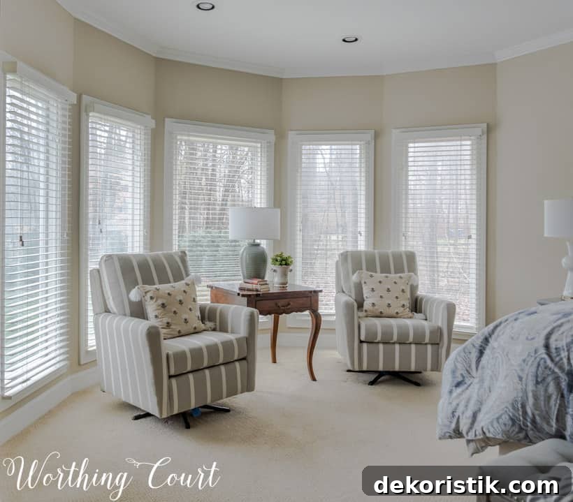 A neutral room with two armchairs and pillows.