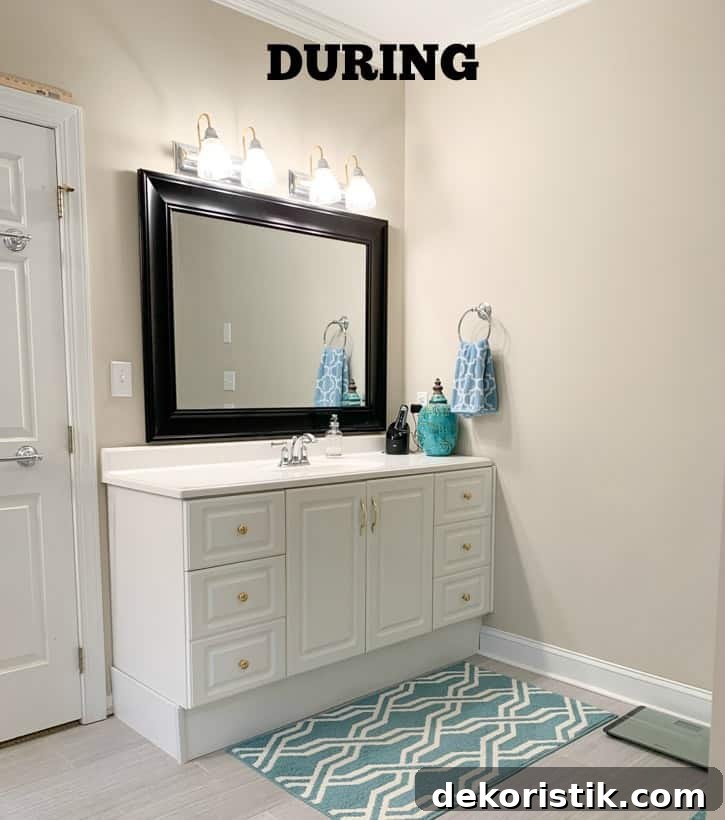 White cabinets and a bold dark mirror in the bathroom.