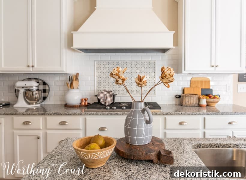 fall decor in kitchen with white cabinets and granite counters
