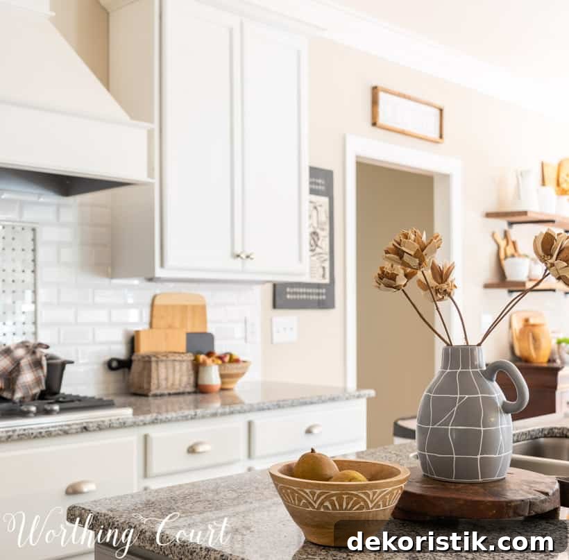 fall decor in kitchen with white cabinets and granite counters