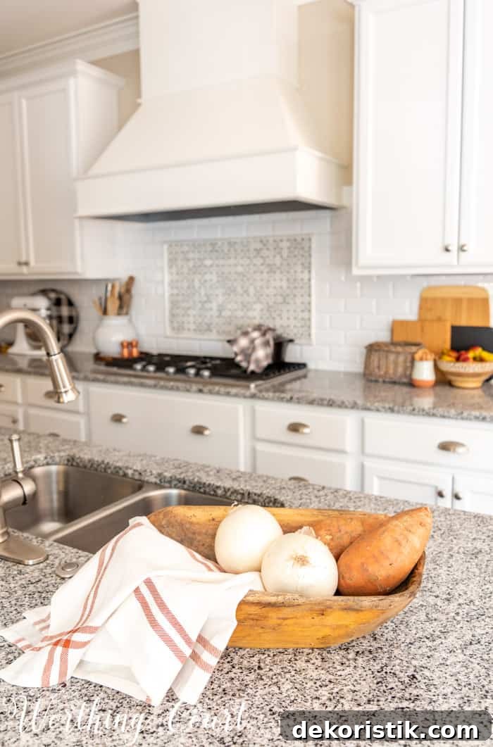 fall decor in kitchen with white cabinets and granite counters