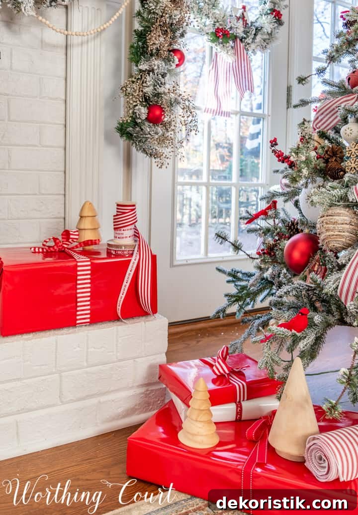 Red and White Flocked Christmas Tree with Snowy Branches 5 Christmas presents in red wrapping paper with red and white ribbon beside Christmas tree