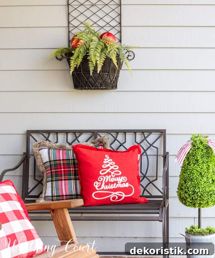 black outdoor bench with Christmas pillows
