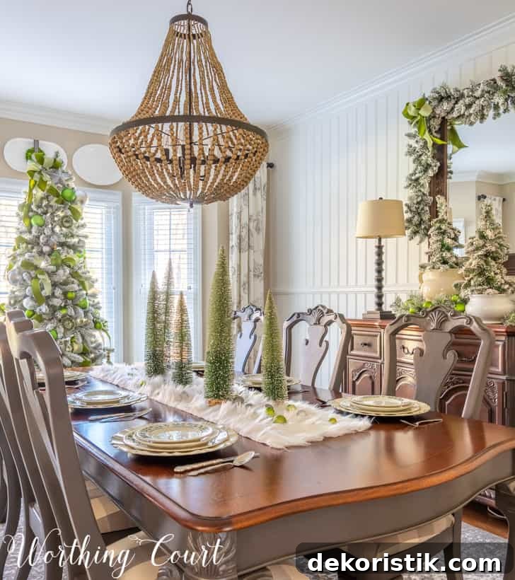 Dining room Christmas decor with flocked trees and silver-green ornaments