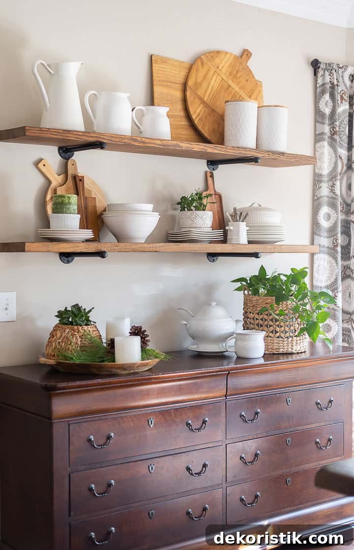 open shelves above wood sideboard decorated for winter with white dishes