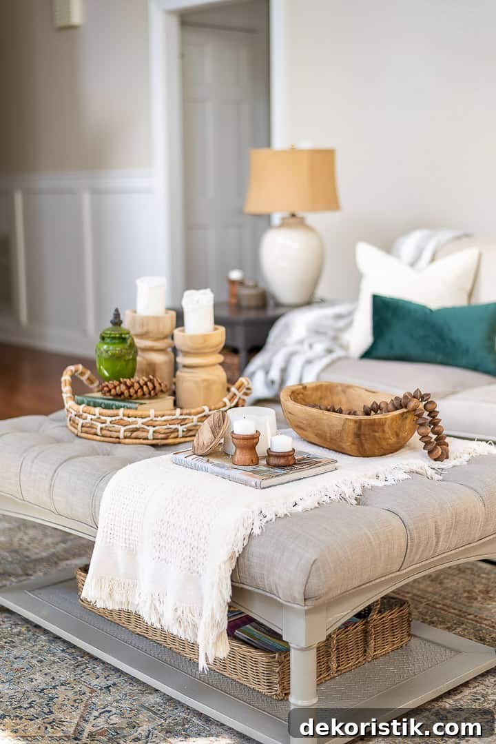 upholstered coffee table decorated with a folded throw and wood accessories